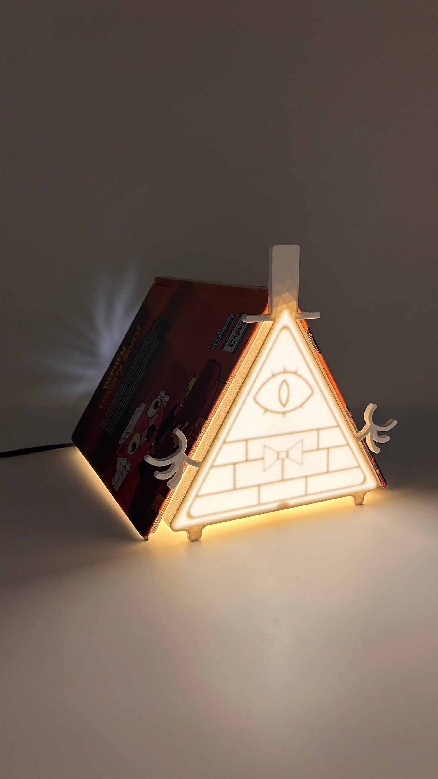Triangular light fixture with pyramid design on a dark background