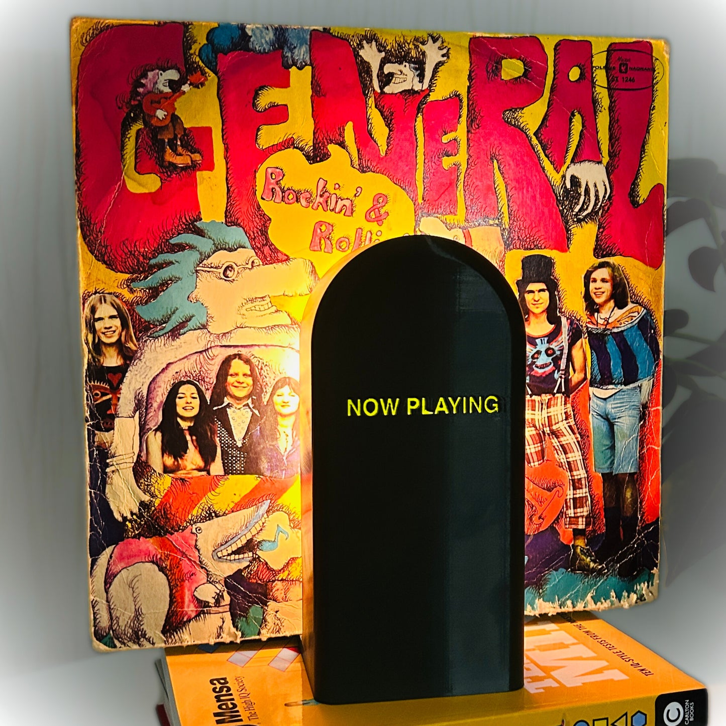 Decorative bookend with 'Now Playing' text against a colorful album cover background
