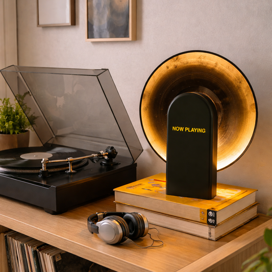 Turntable with a 'Now Playing' lamp on a wooden surface, surrounded by vinyl records and headphones.